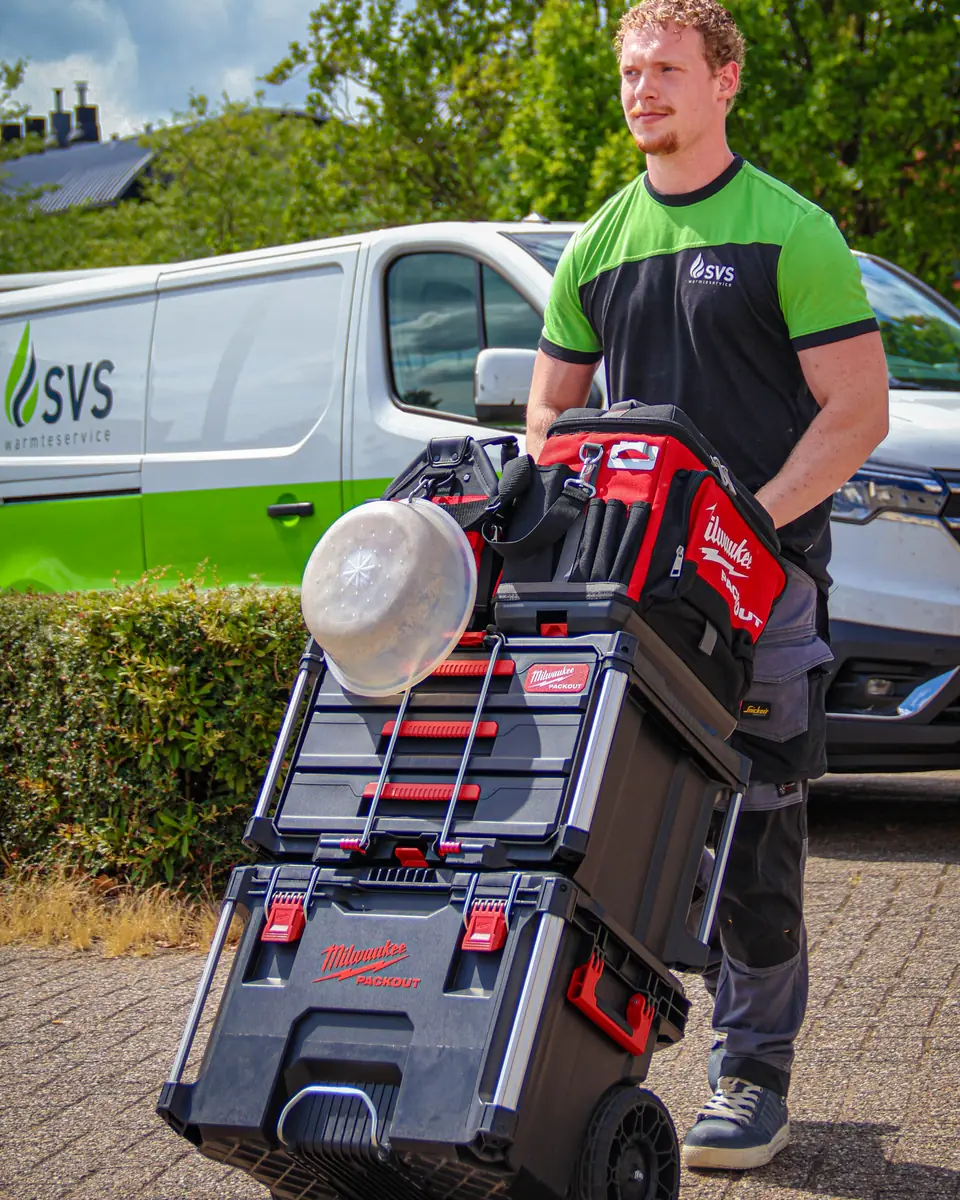 An SVS Warmteservice engineer with his tool trolley in front of the service van.