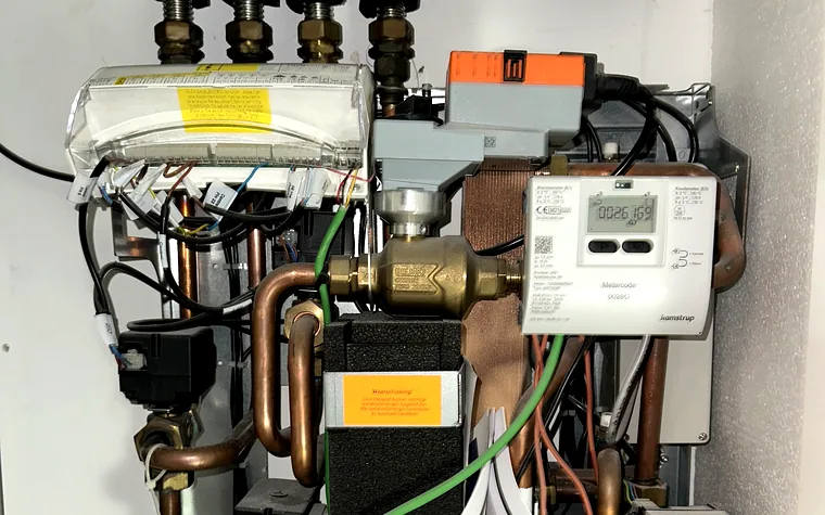 Geopende afleverset met warmtemeter, wisselklep en vuilfilter tijdens onderhoud door SVS Warmteservice.